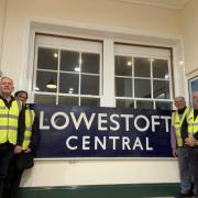 Lowestoft Central Project team members with the former station 'running in board' sign. Picture: Wherry Lines CRP/Lowestoft Central Project