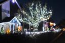 A tree and a home lit up on Christmas Lane in Oulton Broad.