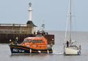 Lowestoft Lifeboat crew members connecting a tow line to bring the stranded 33ft yacht back into Lowestoft. Picture: Mick Howes
