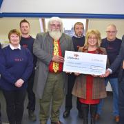 Lifeboat treasurer Peter Boardman receiving a cheque from Andy and Paula Bond in front of members of Lowestoft Lifeboat crew. Picture: Mick Howes/RNLI