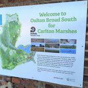 New signage at Oulton Broad South rail station encourages visitors of Carlton Marshes to travel by train
