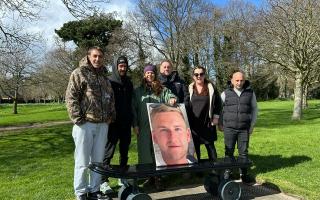 Family, friends and pro skater Chewy Cannon, with a photo of Ollie Nicholls, at the unveiling of the new skateboard memorial bench in Normanston Park, Lowestoft. Picture: The Nicholls family